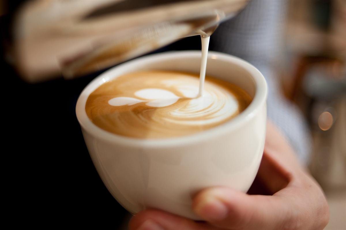 Latte dengan lukisan di permukaannya, diseduh di cafe